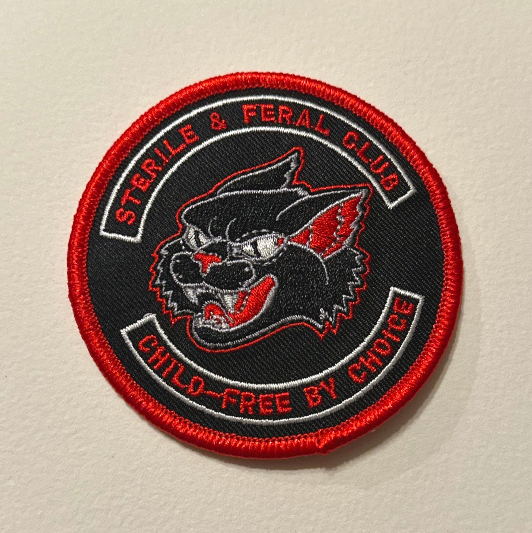 Patch with a cat design and text on a beige background